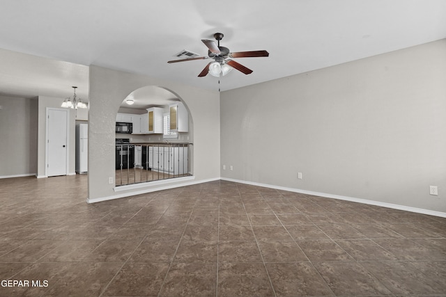 unfurnished living room with visible vents, baseboards, arched walkways, and ceiling fan with notable chandelier