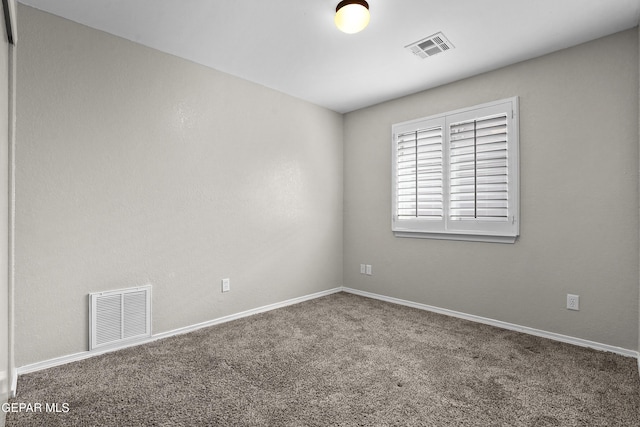 empty room featuring carpet, visible vents, and baseboards