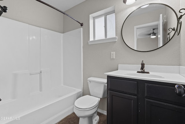 full bath featuring a textured wall, toilet, vanity, and shower / tub combination