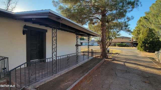 doorway to property with driveway and stucco siding