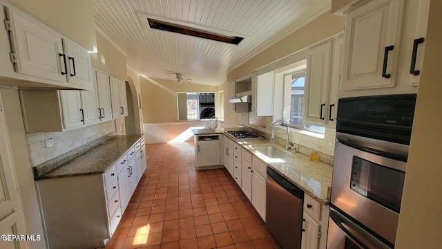 kitchen featuring a sink, tasteful backsplash, stainless steel dishwasher, and tile patterned flooring