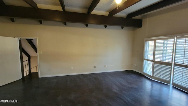 unfurnished room with beamed ceiling and baseboards