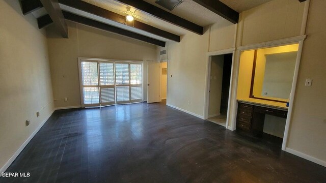 unfurnished living room with lofted ceiling with beams, visible vents, and baseboards