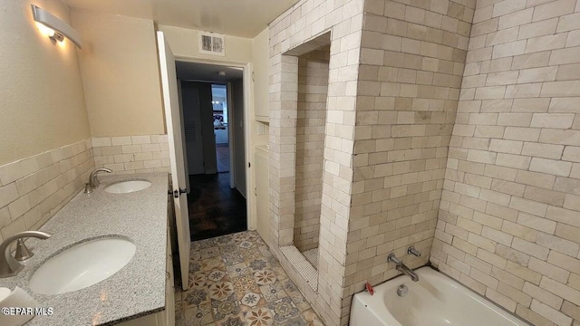 full bath featuring a sink, walk in shower, a tub, and double vanity