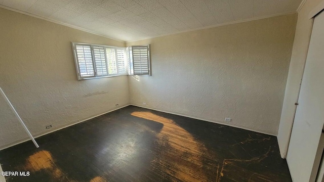 unfurnished bedroom featuring dark wood finished floors, crown molding, and a textured wall