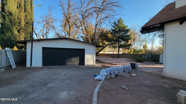 exterior space featuring an outbuilding, fence, and a garage