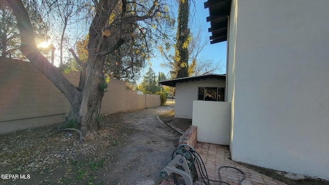 view of property exterior with stucco siding and fence