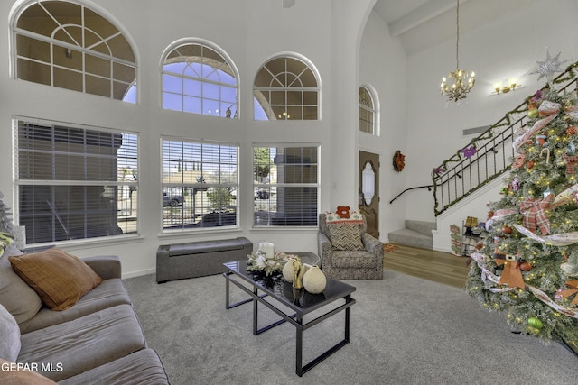 living room featuring arched walkways, carpet, an inviting chandelier, a towering ceiling, and stairs