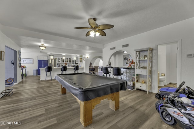 game room with billiards, a ceiling fan, wood finished floors, visible vents, and arched walkways