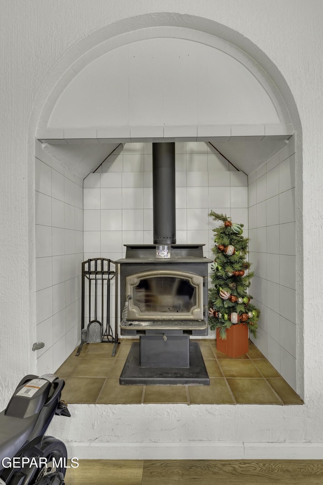 room details featuring a wood stove and a textured wall