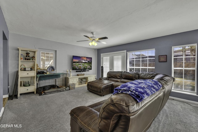 carpeted living area with baseboards, a textured ceiling, and ceiling fan