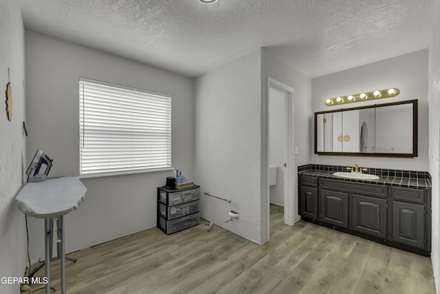 bathroom featuring a textured ceiling, vanity, and wood finished floors