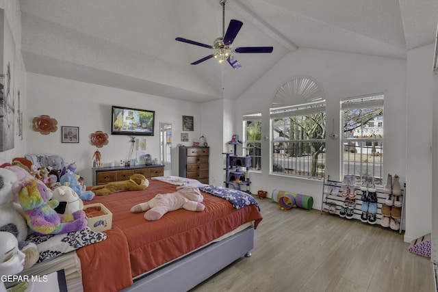 bedroom featuring beam ceiling, high vaulted ceiling, wood finished floors, and a ceiling fan