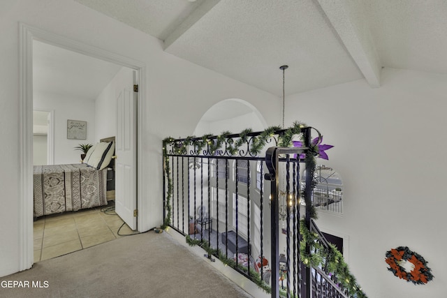 corridor with lofted ceiling with beams, carpet, and a textured ceiling