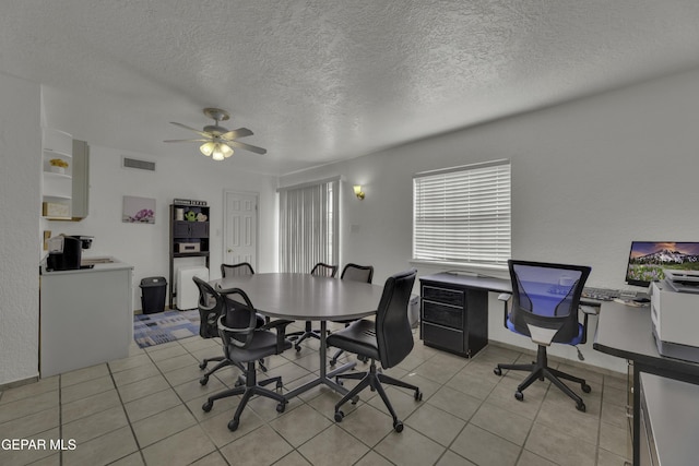 dining area featuring light tile patterned floors, visible vents, a textured ceiling, and a ceiling fan