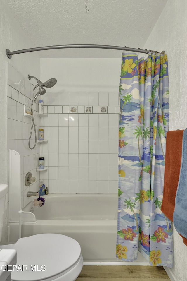 full bathroom featuring toilet, wood finished floors, shower / tub combo, and a textured ceiling