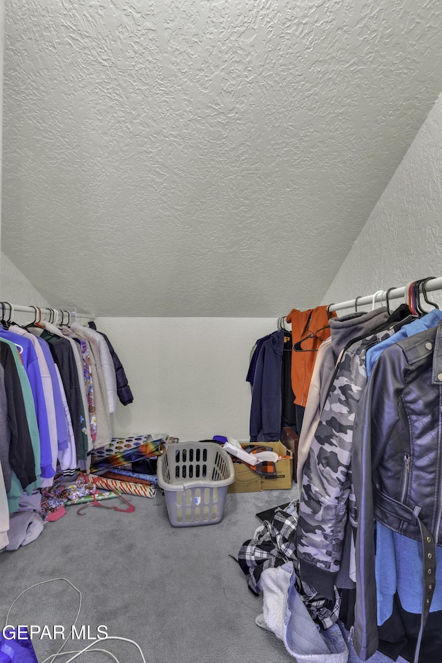 walk in closet featuring lofted ceiling and carpet