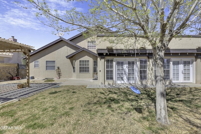 rear view of property featuring a patio area, french doors, a pergola, and stucco siding