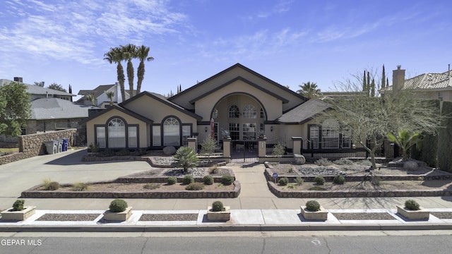 view of front of house with stucco siding, a fenced front yard, and french doors