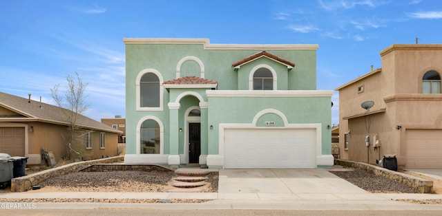 mediterranean / spanish-style house featuring stucco siding, an attached garage, driveway, and a tiled roof