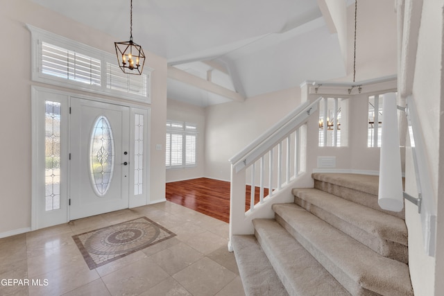 foyer featuring high vaulted ceiling, a notable chandelier, light tile patterned floors, baseboards, and stairs