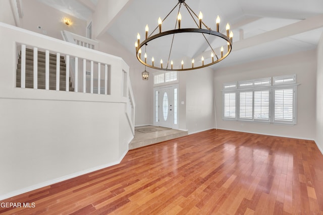 foyer entrance with a chandelier, high vaulted ceiling, baseboards, and hardwood / wood-style flooring