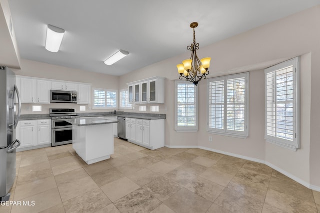 kitchen featuring a notable chandelier, a kitchen island, white cabinetry, and stainless steel appliances