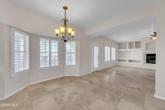 unfurnished living room with built in shelves, ceiling fan with notable chandelier, a glass covered fireplace, baseboards, and vaulted ceiling