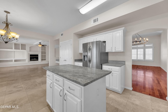 kitchen with visible vents, a center island, stainless steel fridge with ice dispenser, built in features, and white cabinets