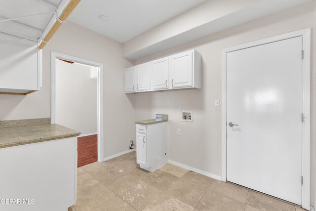 clothes washing area with baseboards, cabinet space, and hookup for a washing machine