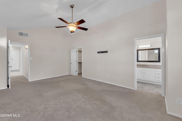 unfurnished bedroom featuring a sink, high vaulted ceiling, visible vents, and light carpet