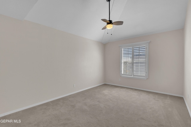 carpeted empty room with vaulted ceiling, baseboards, and ceiling fan