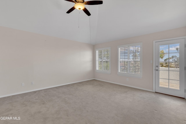 empty room featuring baseboards, carpet floors, a ceiling fan, and vaulted ceiling