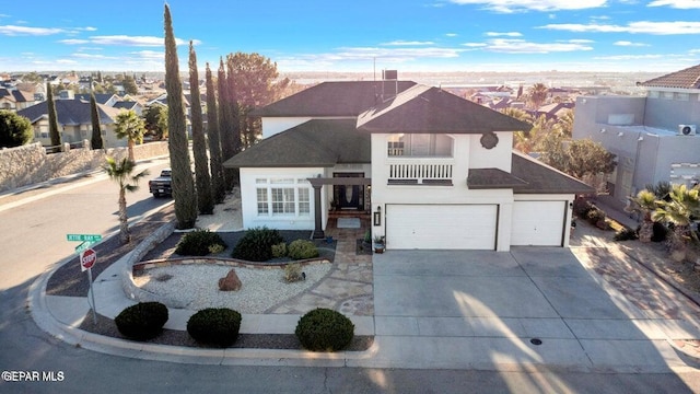 traditional-style house with roof with shingles, an attached garage, stucco siding, concrete driveway, and a residential view