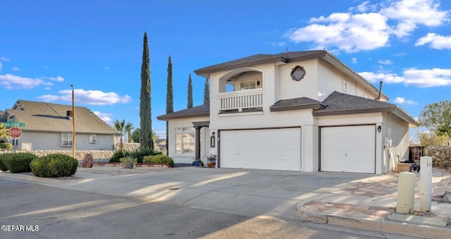 view of front of house with a balcony, driveway, an attached garage, stucco siding, and a garage