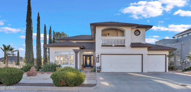 view of front of property with stucco siding, driveway, roof with shingles, an attached garage, and a balcony