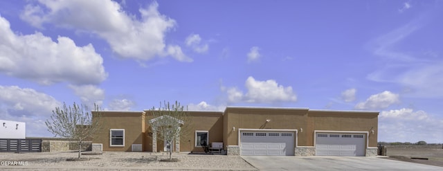 adobe home with stucco siding, concrete driveway, a garage, and fence