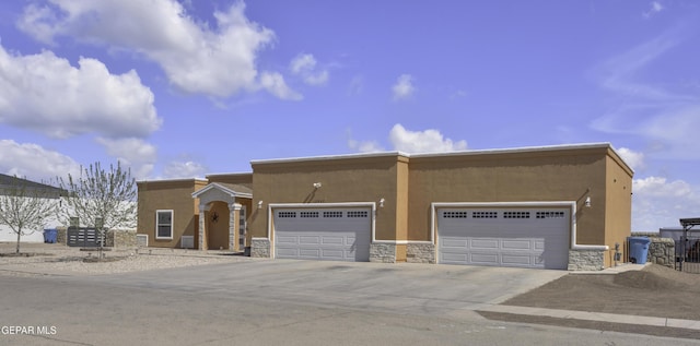 view of front facade with stucco siding, an attached garage, and concrete driveway