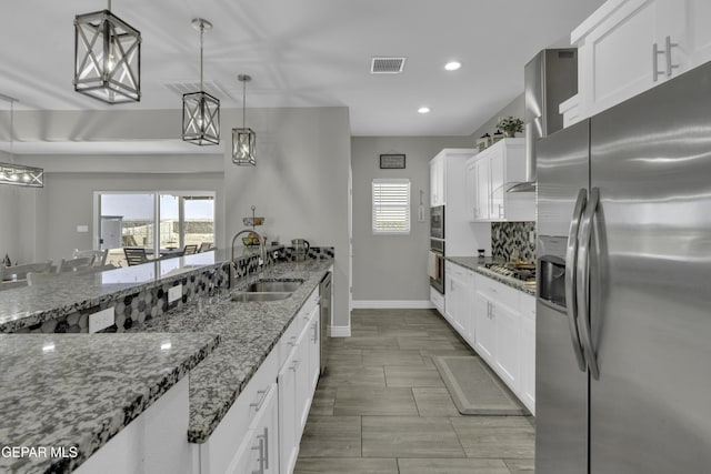 kitchen with visible vents, white cabinets, stainless steel appliances, and a sink