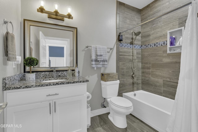 full bath featuring toilet, wood finished floors, shower / tub combo, baseboards, and vanity