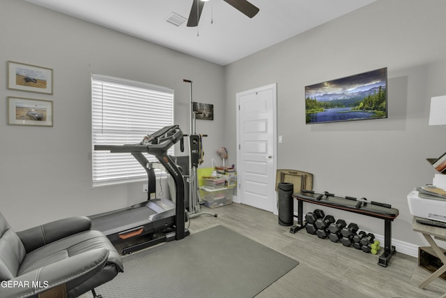 exercise area with wood finished floors, a ceiling fan, visible vents, and baseboards