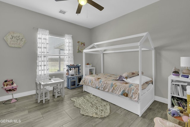 bedroom with a ceiling fan, baseboards, visible vents, and wood finish floors