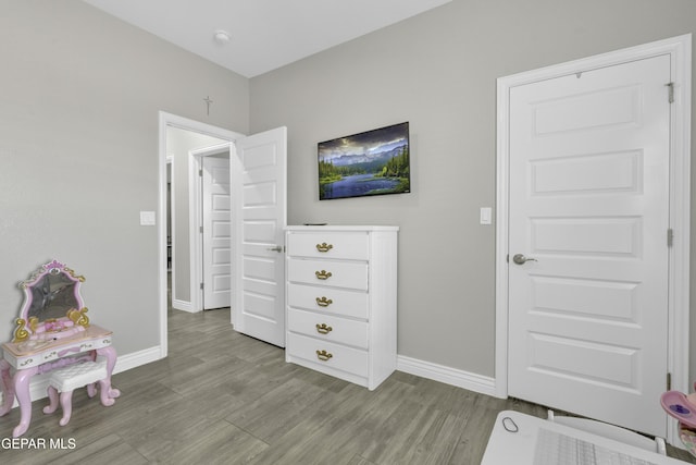 recreation room featuring baseboards and wood finished floors