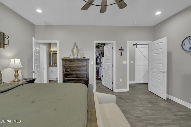 bedroom with recessed lighting, connected bathroom, baseboards, and a spacious closet