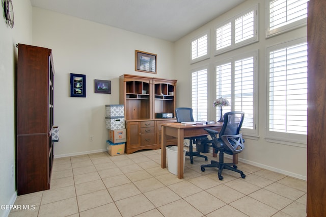 office space featuring light tile patterned flooring, a healthy amount of sunlight, and baseboards