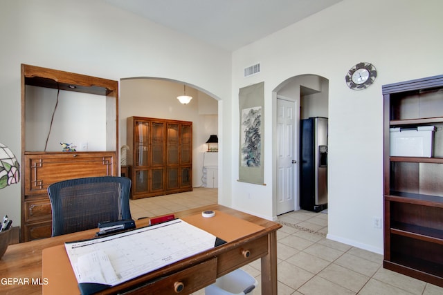 office area featuring tile patterned floors, visible vents, and arched walkways