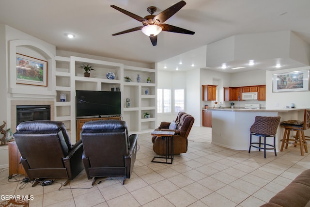 living room featuring lofted ceiling, light tile patterned flooring, a fireplace, and ceiling fan