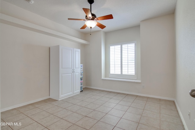 unfurnished room with baseboards and ceiling fan