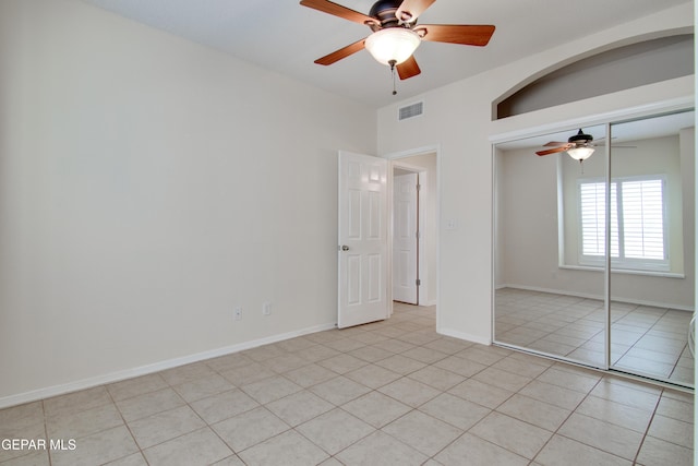 unfurnished bedroom featuring light tile patterned floors, visible vents, ceiling fan, and a closet