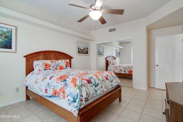 bedroom with light tile patterned floors, baseboards, visible vents, ceiling fan, and a closet